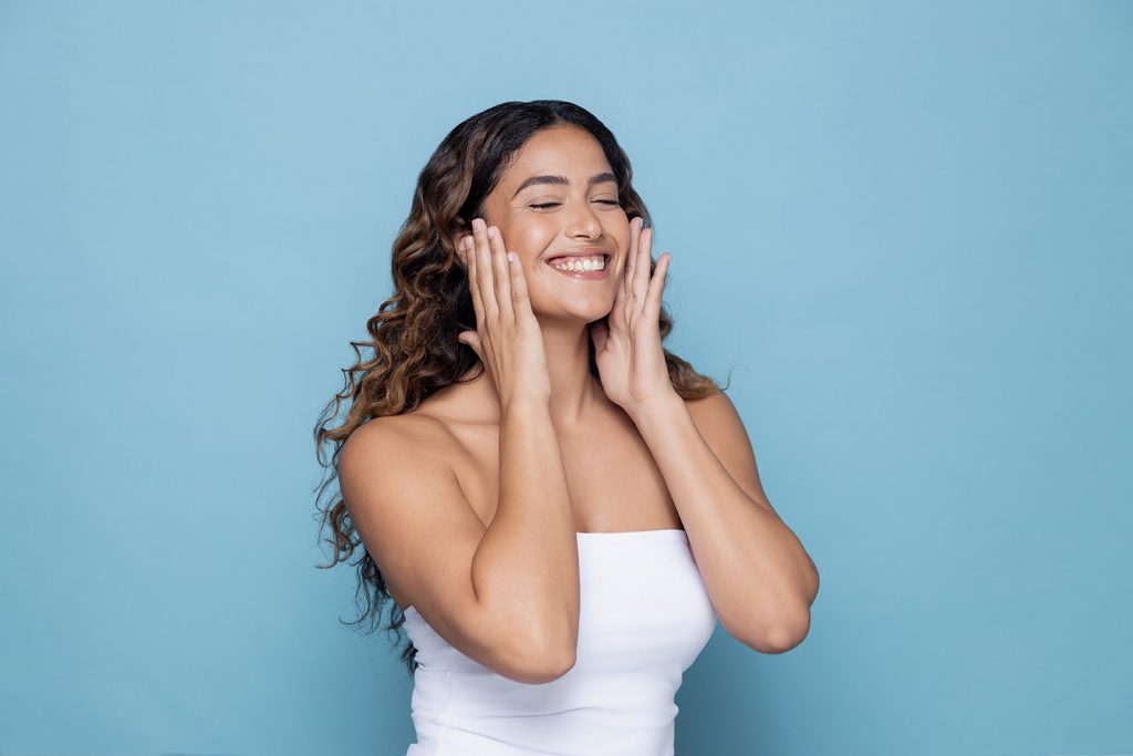 Lady smiling touching her face